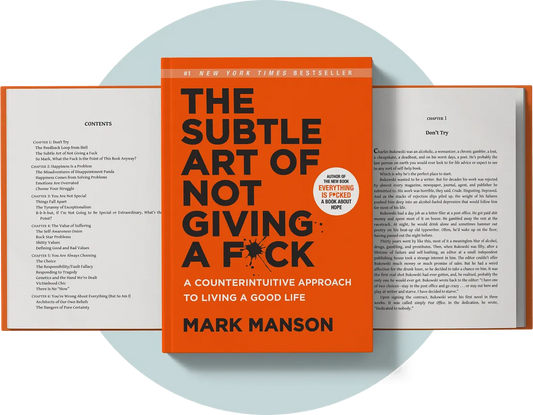 Book cover and open interior pages of The Subtle Art of Not Giving a F*ck by Mark Manson, shown on a white background with a pale blue oval backdrop behind the book.