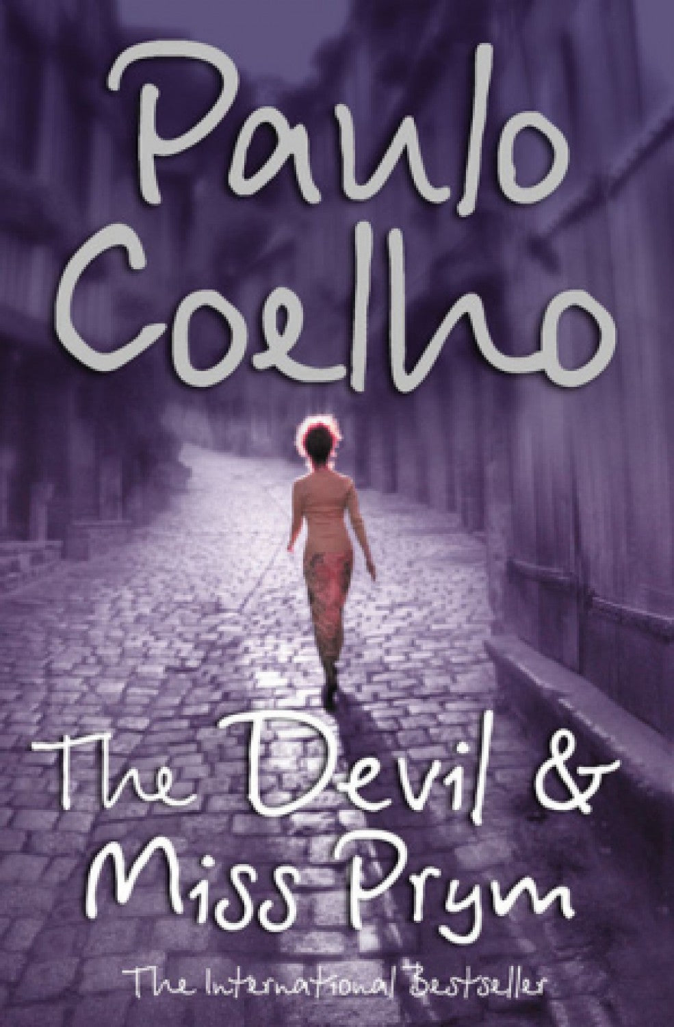 Book cover of 'The Devil & Miss Prym' by Paulo Coelho with a woman walking down a cobbled street.